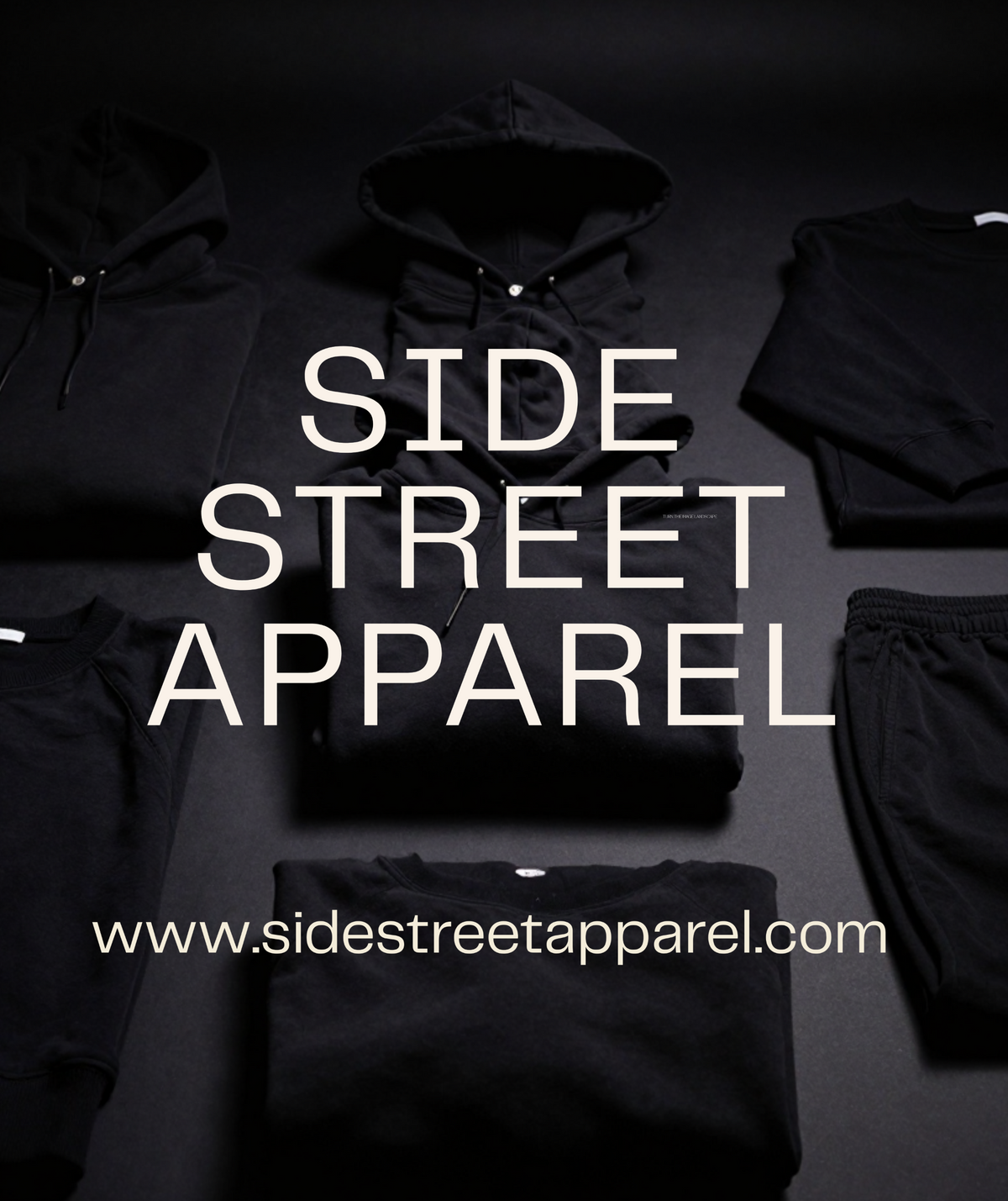 A flat-lay display of folded black apparel, including hoodies, sweatshirts, and sweatpants, arranged on a dark background with large white text reading 'SIDE STREET APPAREL' and the website 'www.sidestreetapparel.